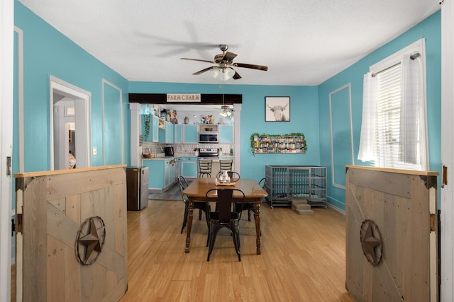 dining space featuring ceiling fan, light hardwood / wood-style flooring, and a textured ceiling