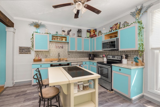 kitchen featuring stainless steel appliances, hardwood / wood-style flooring, sink, and blue cabinets