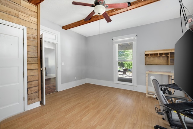 home office featuring ceiling fan, beamed ceiling, and light wood-type flooring