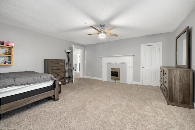 bedroom featuring light carpet, ceiling fan, a fireplace, and a textured ceiling