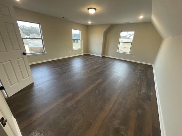 additional living space featuring dark wood-style floors, baseboards, and vaulted ceiling