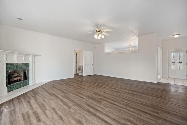 unfurnished living room featuring crown molding, ceiling fan, a high end fireplace, and light wood-type flooring