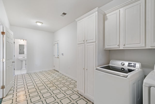 washroom featuring cabinets, electric panel, and washer and clothes dryer