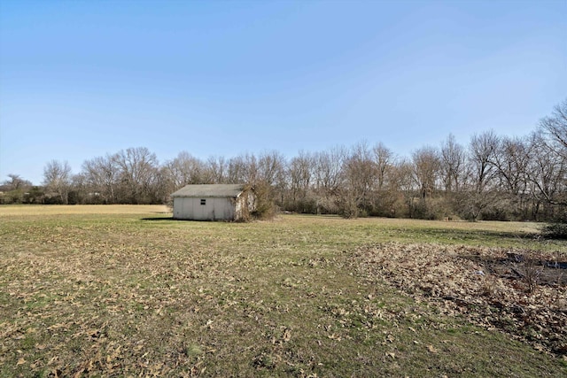 view of yard featuring a rural view and a storage shed