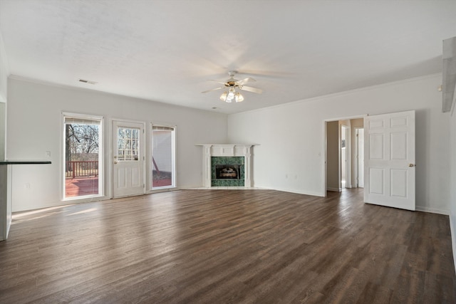 unfurnished living room featuring dark hardwood / wood-style flooring, a high end fireplace, ornamental molding, and ceiling fan