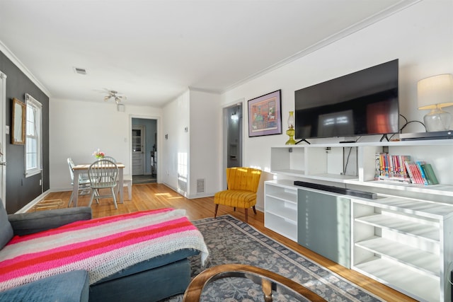 living room featuring ornamental molding and light hardwood / wood-style floors