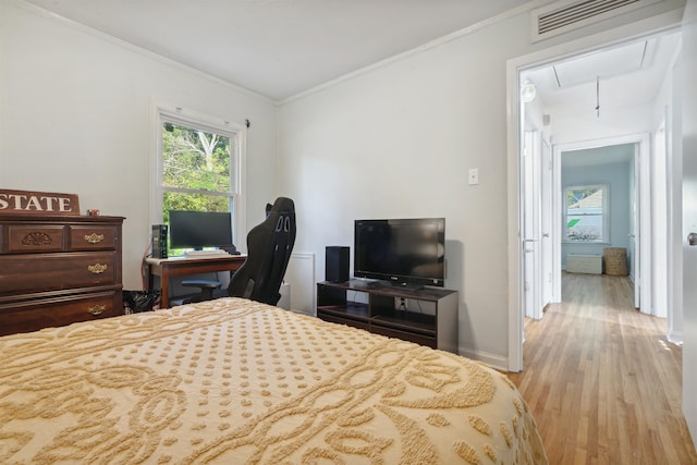 bedroom featuring crown molding and light hardwood / wood-style floors