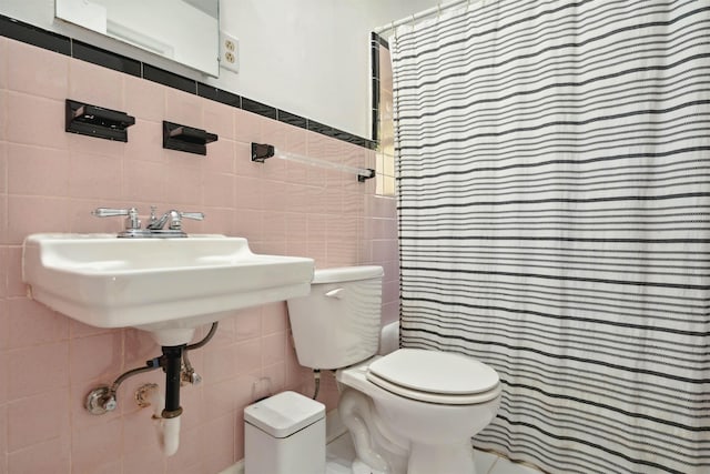 bathroom with walk in shower, tile walls, and toilet