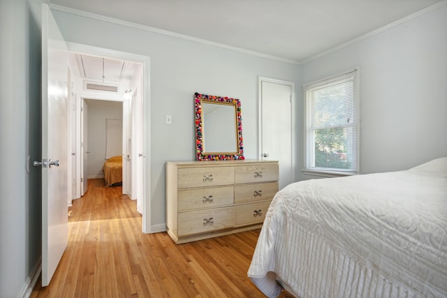 bedroom featuring ornamental molding and light hardwood / wood-style floors