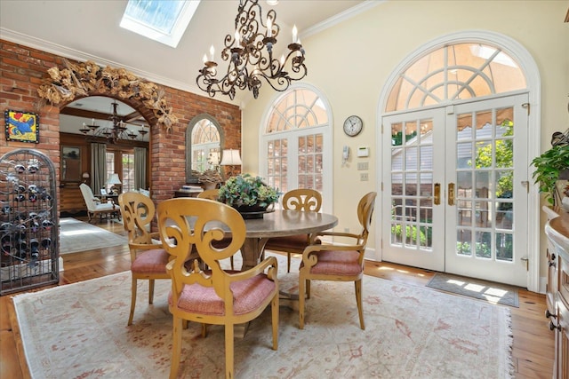 dining room with french doors, crown molding, a chandelier, and light wood-type flooring