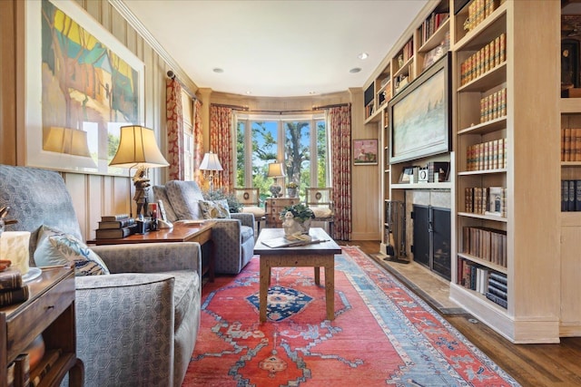 living area with ornamental molding and dark wood-type flooring