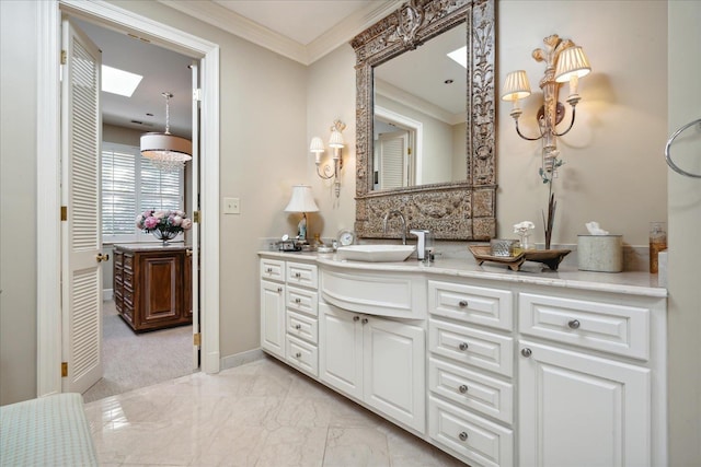 bathroom with crown molding, vanity, and a skylight