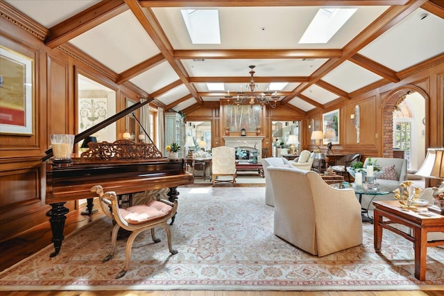 living room featuring wooden walls, lofted ceiling with skylight, and a chandelier