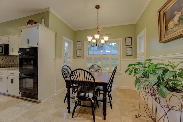 dining space with ornamental molding and a chandelier