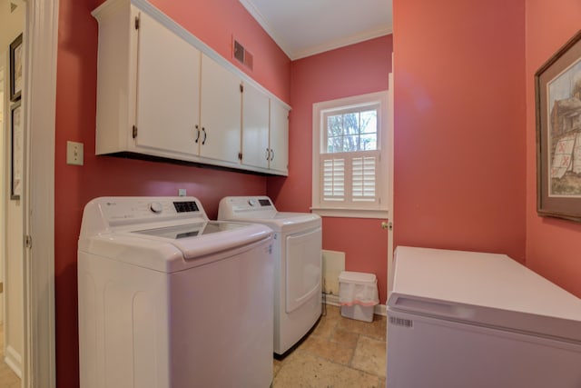 laundry room with cabinets, ornamental molding, and washing machine and dryer