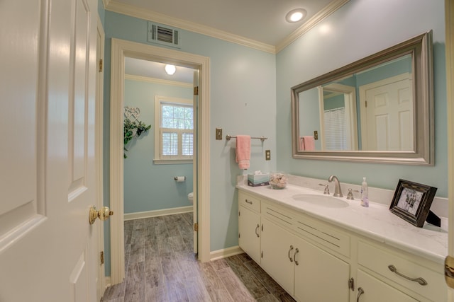 bathroom featuring crown molding, vanity, toilet, and hardwood / wood-style flooring