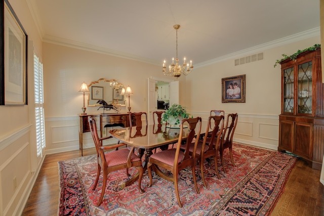 dining area with an inviting chandelier, ornamental molding, and wood-type flooring