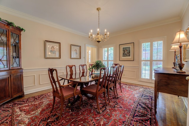 dining space with dark hardwood / wood-style flooring, plenty of natural light, ornamental molding, and a chandelier