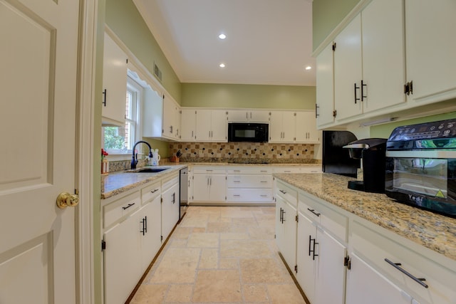 kitchen with white cabinetry, light stone countertops, and sink