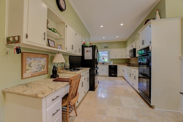 kitchen with light stone countertops, built in desk, white cabinets, and black appliances