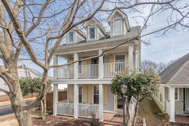 cape cod-style house with a porch and a balcony