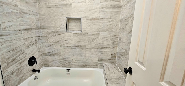 bathroom featuring tiled shower / bath