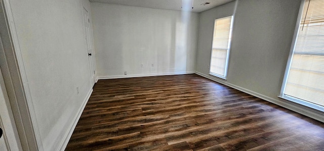 empty room with dark hardwood / wood-style flooring