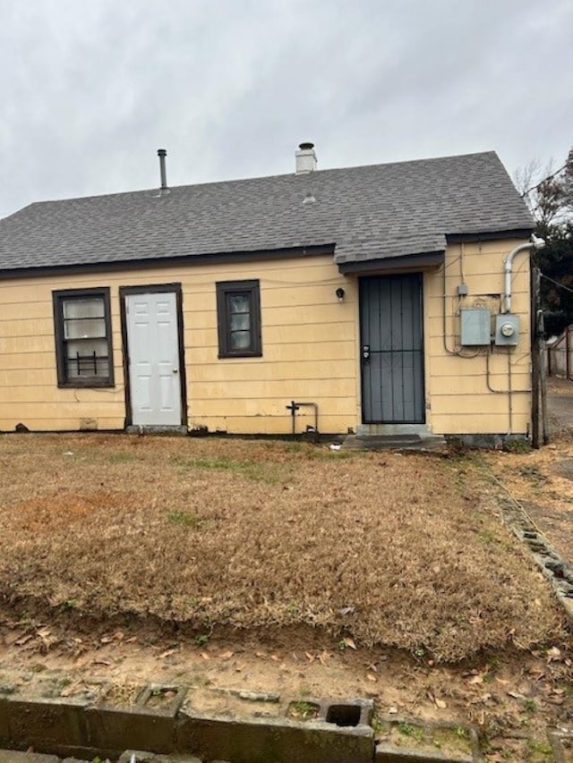 rear view of property with a yard