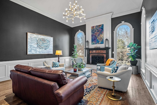 living room featuring ornamental molding, wood-type flooring, and an inviting chandelier