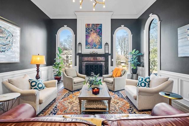 living room with crown molding, an inviting chandelier, and a wealth of natural light