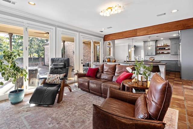 living room with ornamental molding and sink