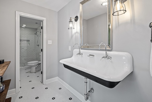 bathroom featuring tile patterned flooring, sink, a tile shower, and toilet