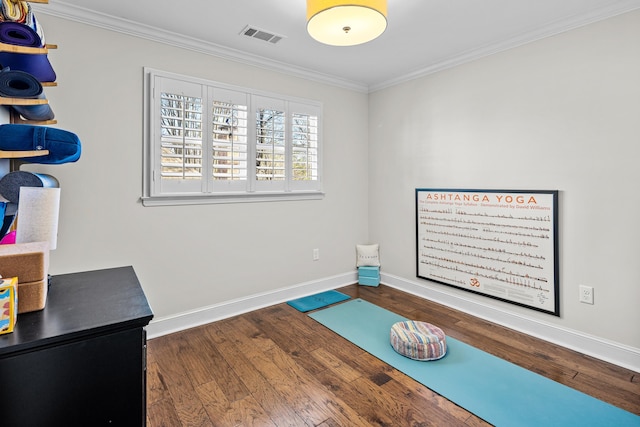 workout room featuring ornamental molding and dark hardwood / wood-style flooring