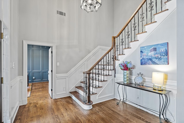 foyer with hardwood / wood-style flooring and a towering ceiling