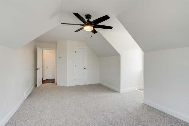 additional living space with lofted ceiling, light colored carpet, and ceiling fan