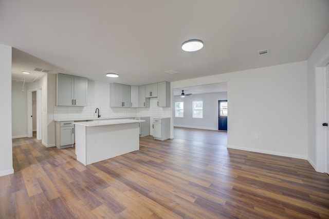 kitchen with tasteful backsplash, sink, a center island, and gray cabinetry