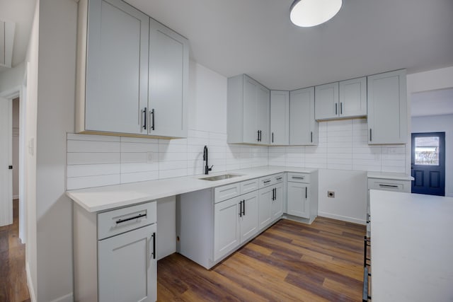 kitchen featuring white cabinetry, dark hardwood / wood-style flooring, sink, and backsplash