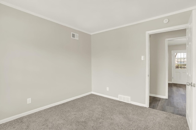 empty room featuring ornamental molding and carpet