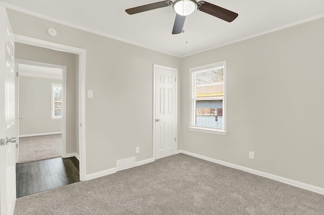 carpeted empty room with ornamental molding and ceiling fan