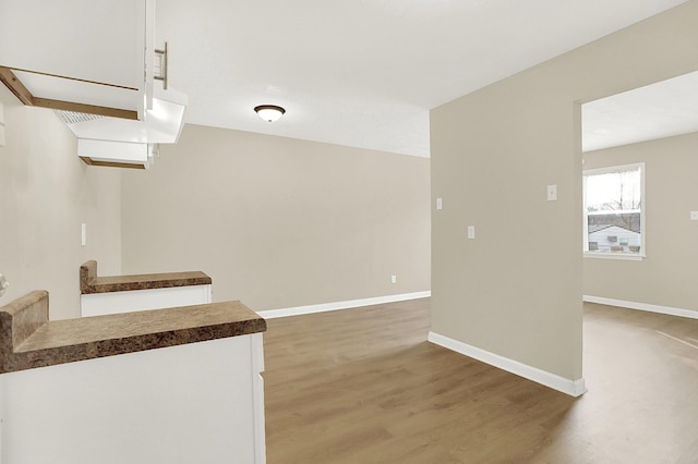 kitchen featuring wood-type flooring and white cabinets