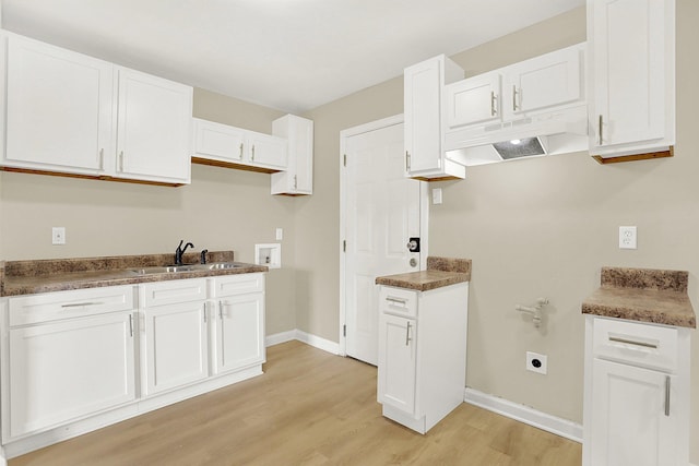 kitchen with sink, light hardwood / wood-style flooring, and white cabinets