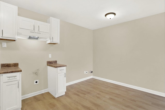 laundry room with electric dryer hookup and light hardwood / wood-style flooring