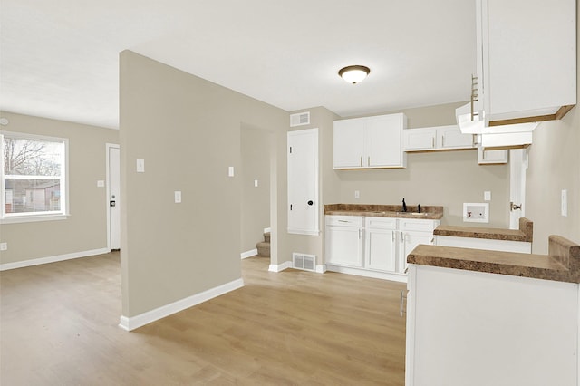 kitchen featuring light hardwood / wood-style floors, sink, and white cabinets