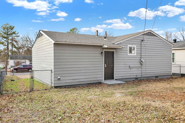 rear view of property featuring a lawn