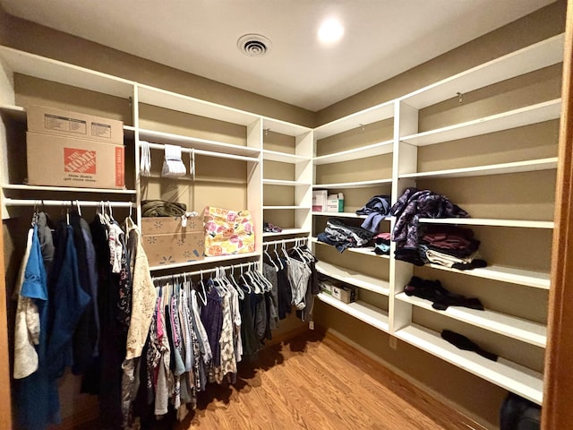 walk in closet with hardwood / wood-style floors