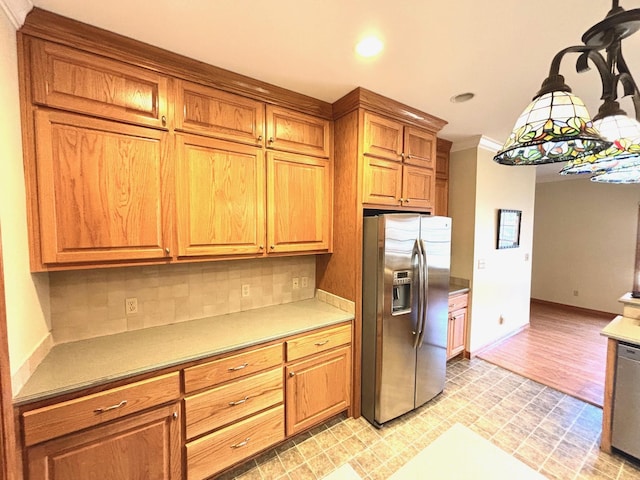 kitchen featuring crown molding, stainless steel appliances, decorative light fixtures, and backsplash