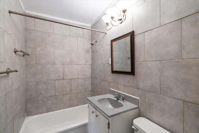 full bathroom featuring tiled shower / bath combo, vanity, tile walls, and toilet