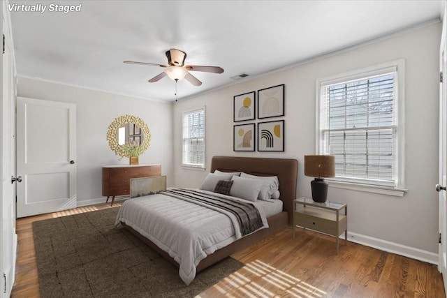 bedroom with wood-type flooring, ornamental molding, and ceiling fan