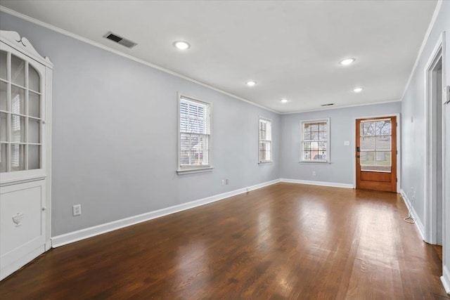 unfurnished room featuring dark wood-type flooring, crown molding, and a wealth of natural light