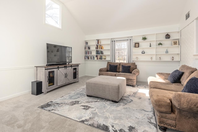 living room with lofted ceiling, carpet flooring, and built in shelves